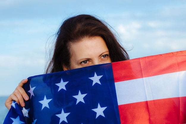 Foto giovane bella donna che tiene la bandiera degli stati uniti?