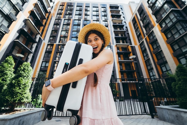 A young beautiful woman holds a suitcase in her hands