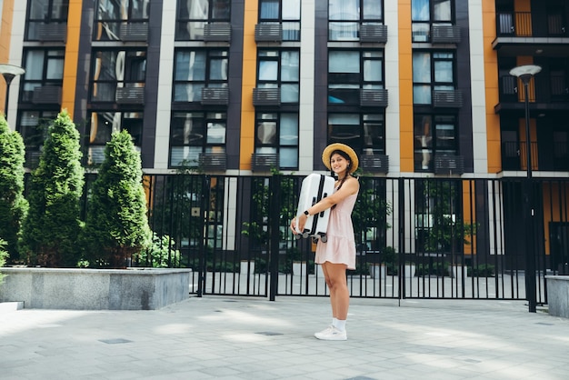 A young beautiful woman holds a suitcase in her hands