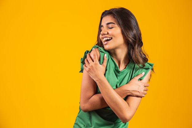 Young beautiful woman hugging oneself happy and positive, smiling confident. self love and self care