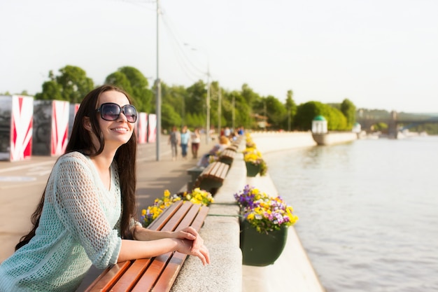 Фото Молодая красивая женщина в солнечных очках в городском парке