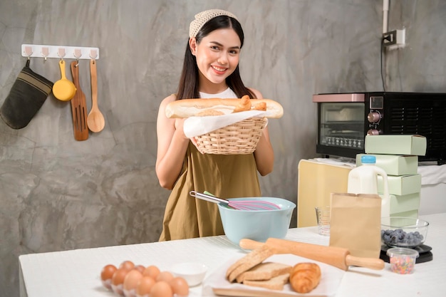 La giovane bella donna sta cuocendo nella sua attività di panetteria e caffetteria in cucina