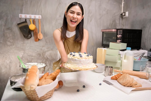 Young beautiful woman is baking in her kitchen bakery and coffee shop business