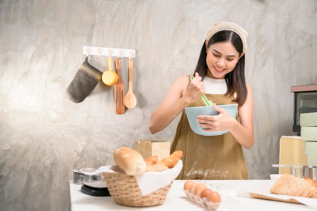 Молодая красивая женщина печет в своей кухонной пекарне и кофейне