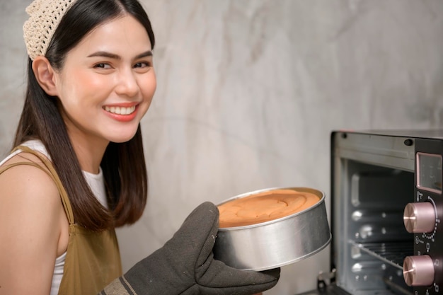 La giovane bella donna sta cuocendo nella sua attività di panetteria e caffetteria in cucina
