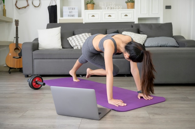 A Young beautiful woman is doing the mountain climber exercise at home