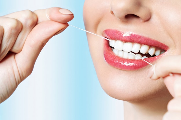 Photo young beautiful woman is engaged in cleaning teeth