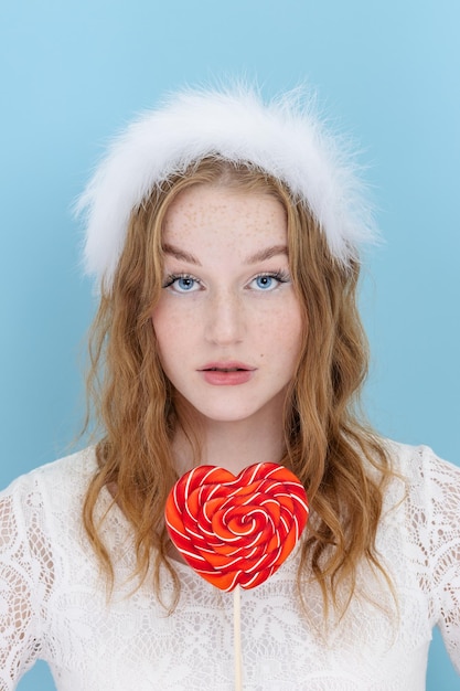 Young beautiful woman is holding a heart shaped candy