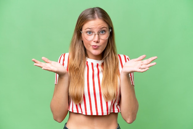 Photo young beautiful woman over isolated background having doubts while raising hands