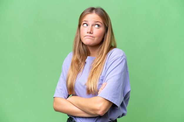 Young beautiful woman over isolated background making doubts gesture while lifting the shoulders