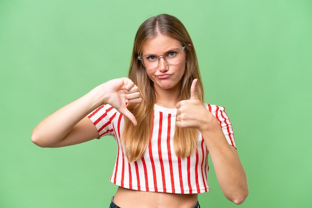 Photo young beautiful woman over isolated background making goodbad sign undecided between yes or not