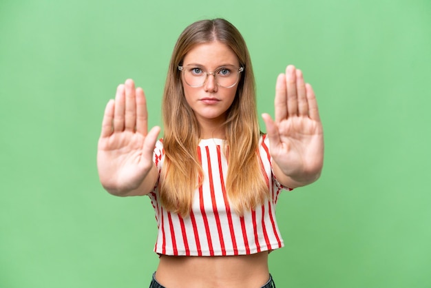 Young beautiful woman over isolated background making stop gesture and disappointed