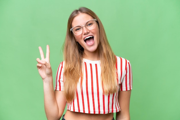 Young beautiful woman over isolated background smiling and showing victory sign