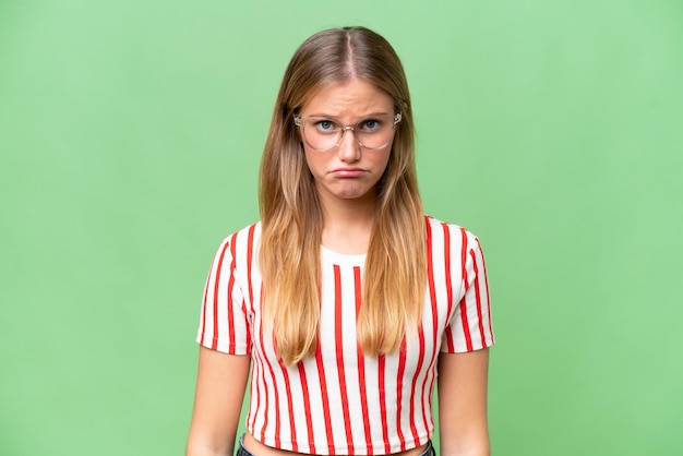 Young beautiful woman over isolated background with sad expression