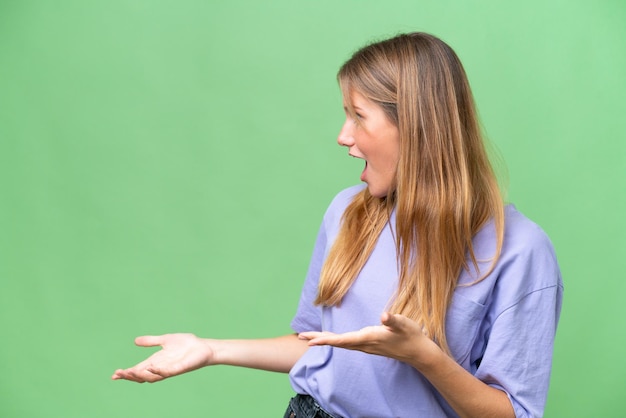 Young beautiful woman over isolated background with surprise expression while looking side