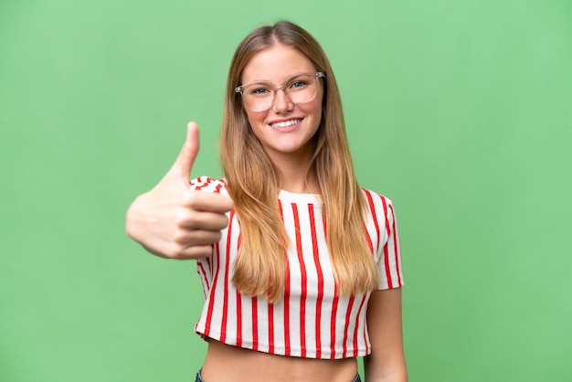 Photo young beautiful woman over isolated background with thumbs up because something good has happened