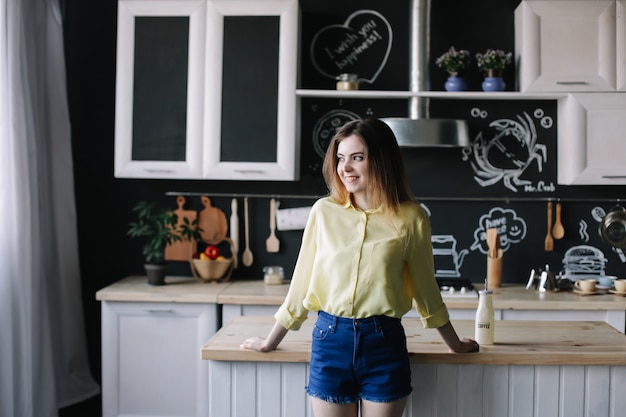 Foto giovane bella donna in cucina a casa