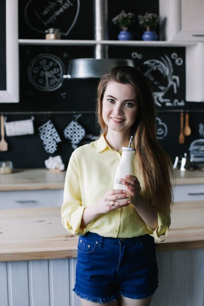 Giovane bella donna in cucina a casa