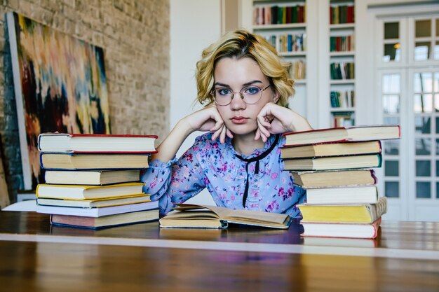 Young beautiful woman in library with books