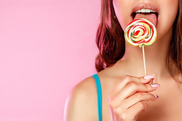 Young beautiful woman licking a lollipop