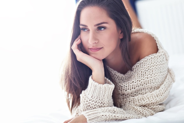 young beautiful woman lying on bed in the morning