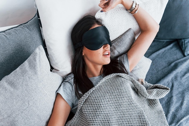 Young beautiful woman in lying down on bed at home alone and sleeping.