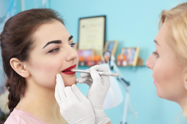 Young beautiful woman making permanent makeup in cosmetology salon