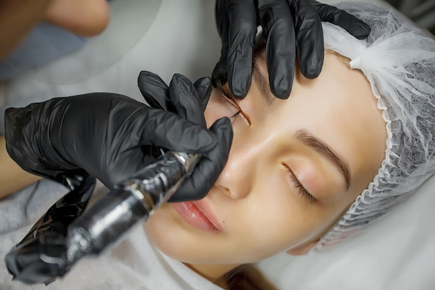 Young beautiful woman making permanent makeup in cosmetology salon