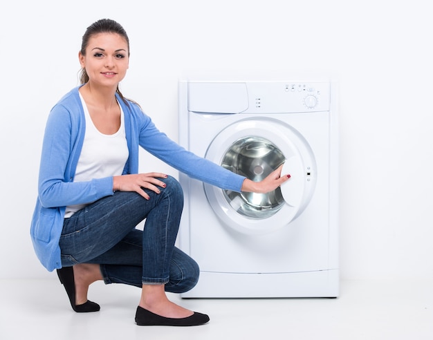 Young beautiful woman near the washing machine.