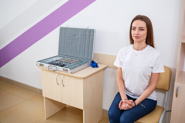 Young beautiful woman at the ophthalmologist's appointment checks her eyesight. Doctor ophthalmologist examines the patient