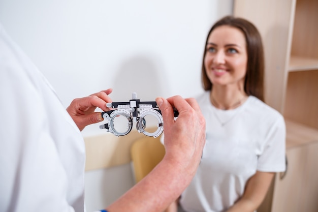 Young beautiful woman at the ophthalmologist's appointment checks her eyesight. Doctor ophthalmologist examines the patient