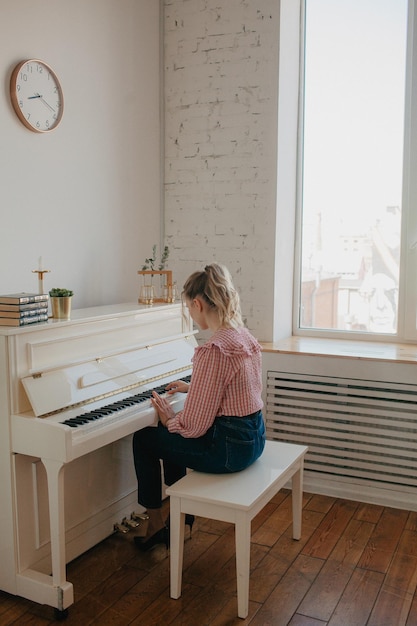 Foto giovane bellissima donna che suona il pianoforte persona foto di alta qualità