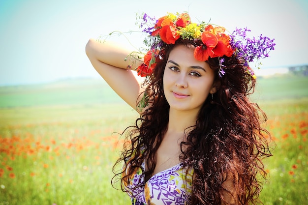 Young beautiful woman in the poppy field