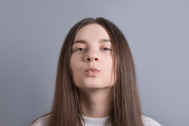 Young beautiful woman portrait with dark hair wearing white sweater