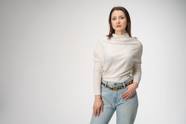 Young beautiful woman posing in jeans on white background