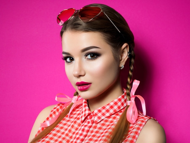 Young beautiful woman posing in pinup style. Smokey eyes and red lips makeup.