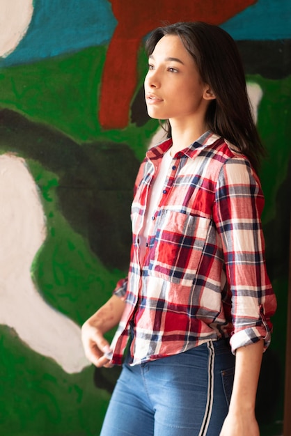 Young beautiful woman posing in a plaid shirt in the studio