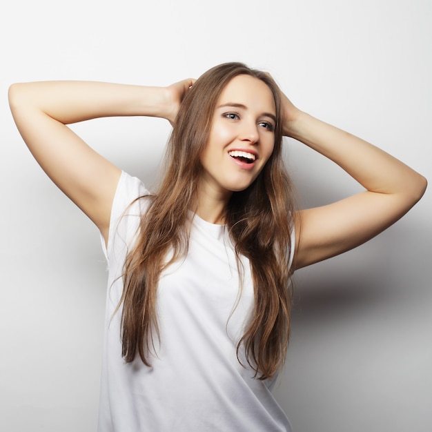 Young beautiful woman posing with  white t-shirts, ower white background