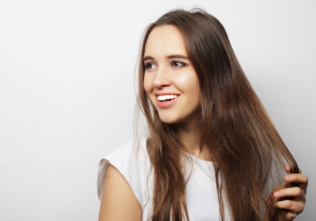 Young beautiful woman posing with  white t-shirts, ower white background