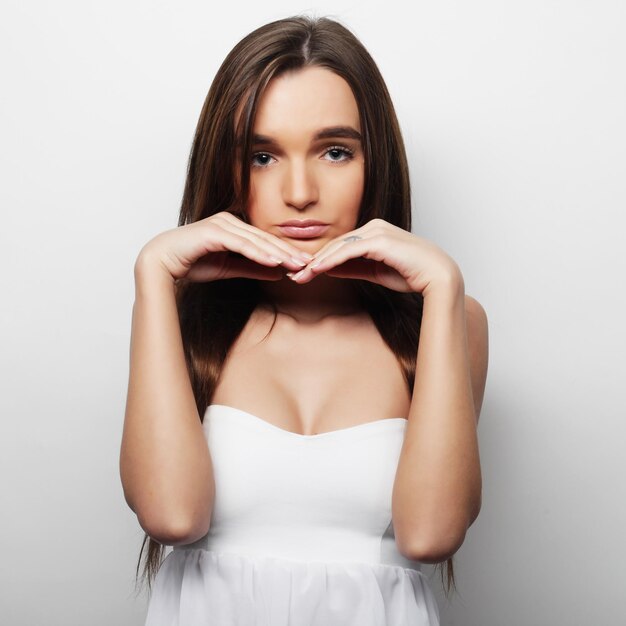 Young beautiful woman posing with white tshirts ower white background