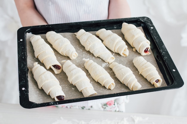 Young beautiful woman preparing homemade croissants