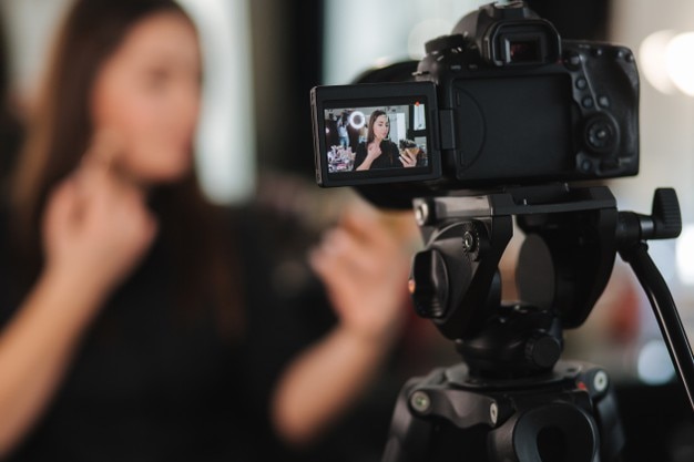 Young beautiful woman and professional beauty make up artist blogger recording makeup tutorial in studio