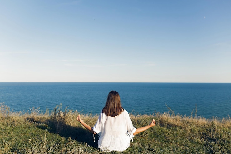 Photo 아름 다운 젊은 여자 편안 하 고 풀밭에 앉아 바다 파도를 듣고 해변에서 요가 연습 요가 meditationcalm 및 행복 요가 하루를 하 고 소식통 소녀