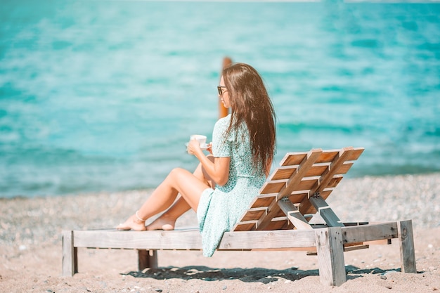 Молодая красивая женщина отдыхает на тропическом пляже с белым песком