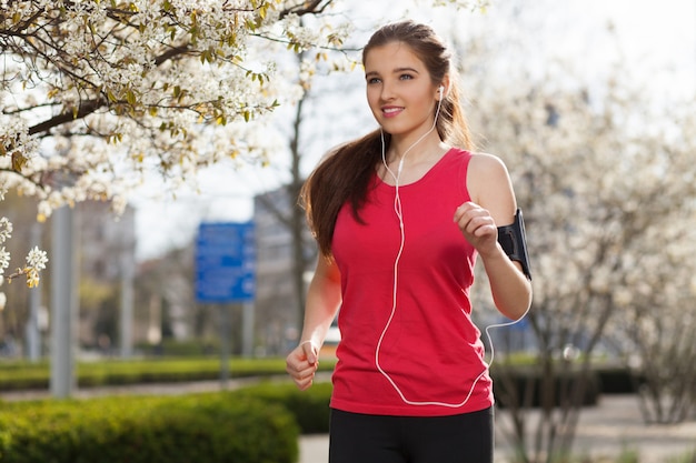 Young beautiful woman running in the city