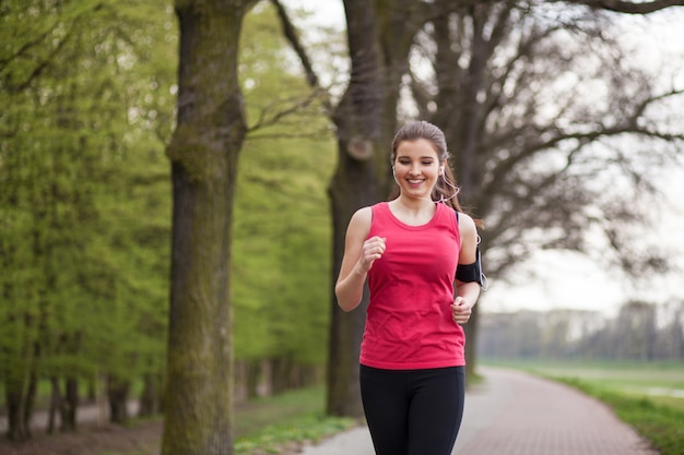 Young beautiful woman running in the city