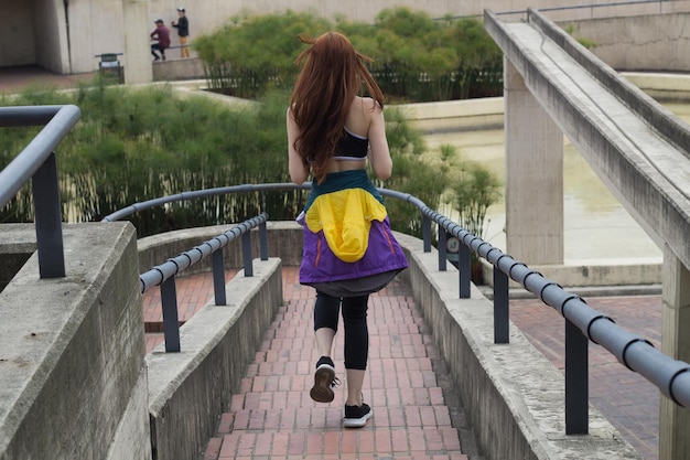 young beautiful woman running in a park in the city