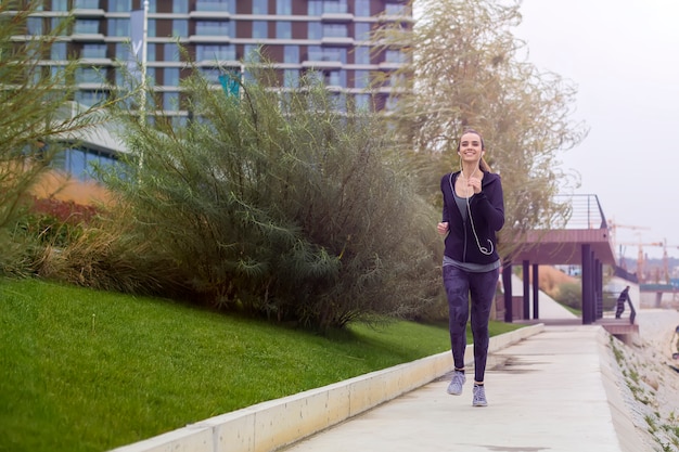 Young beautiful woman running in urban enviroment