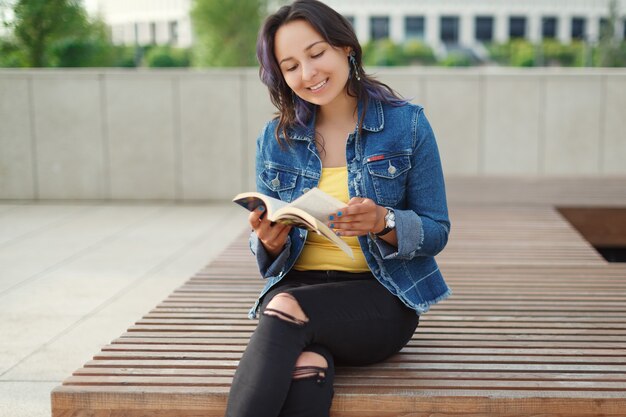 Young beautiful woman sitting on a bench in the Park