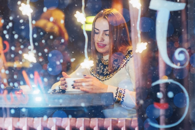 Giovane bella donna che si siede nella caffetteria, bere caffè. natale, capodanno, san valentino, vacanze invernali